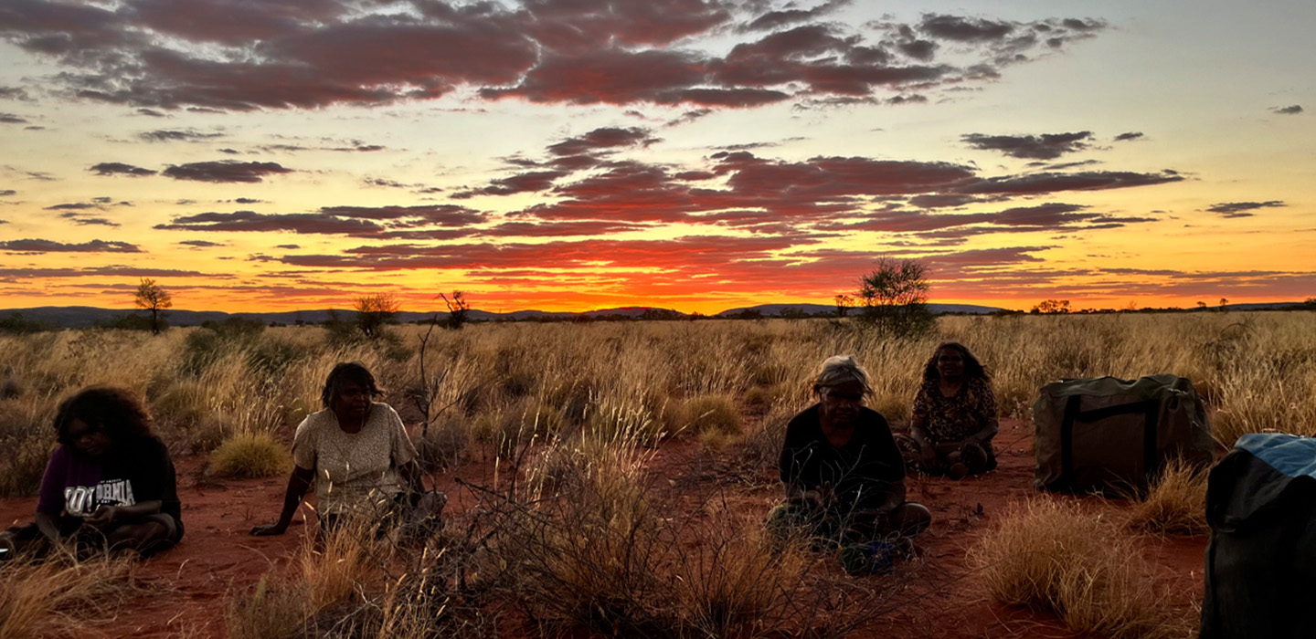 Tjanpi Desert Weavers Corrina Shepherd, Pauline Golding, Winifred Reid and Dianne Golding | Well-earned rest after collecting Tjanpi near Warakurna, WA | Image by Jade Brockley | Image courtesy of Tjanpi Desert Weavers https://tjanpi.com.au/